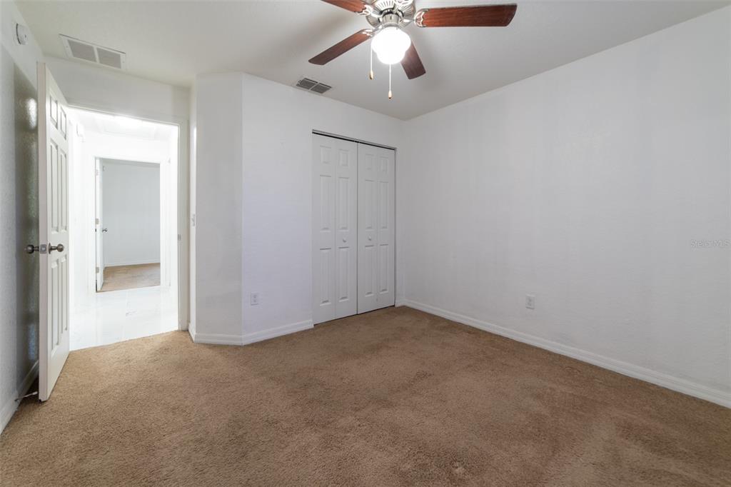 5107 Southwest 165th St Road Ocala, FL 34473 - Photo 26 of 34 an empty room with a ceiling fan and carpet