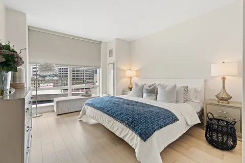 a living room with a bed furniture and a large window