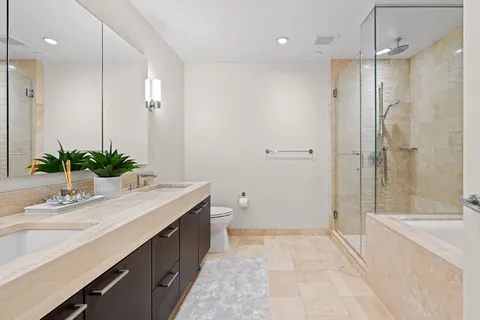 a bathroom with a granite countertop sink a toilet and shower