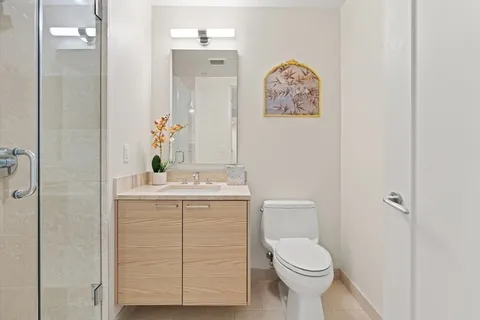 a bathroom with a toilet sink vanity and mirror