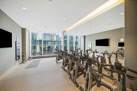 a view of a room with gym equipment and large windows