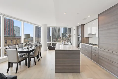 a dining hall with stainless steel appliances kitchen island granite countertop a table and chairs