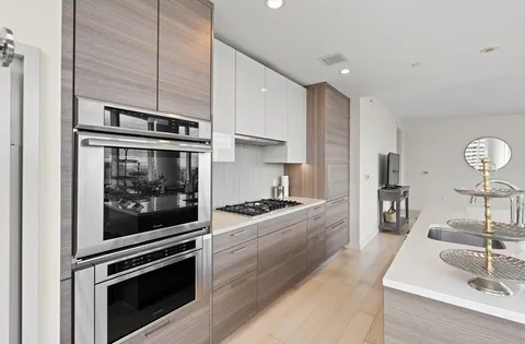 a kitchen with stainless steel appliances kitchen island granite countertop a stove and a sink