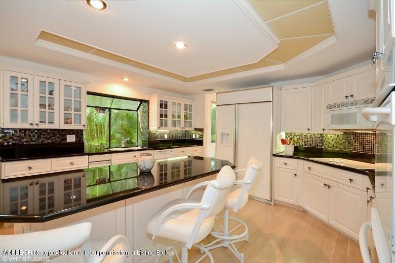 2213 Northwest 60th Road Boca Raton, FL 33496 - Photo 11 of 45 a kitchen with stainless steel appliances kitchen island granite countertop a stove and white cabinets