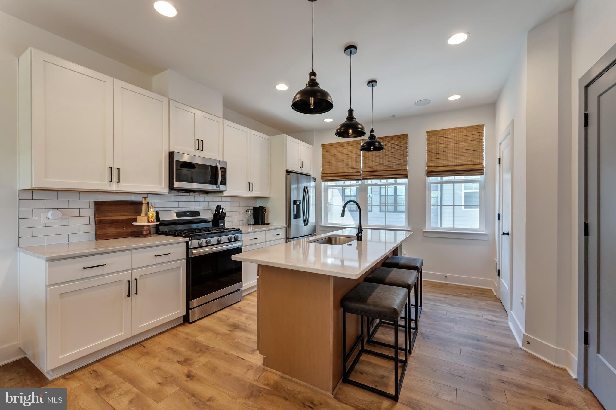 11237 Beaker Street Reston, VA 20190 - Photo 13 of 45 a kitchen with stainless steel appliances granite countertop a sink a stove and a refrigerator