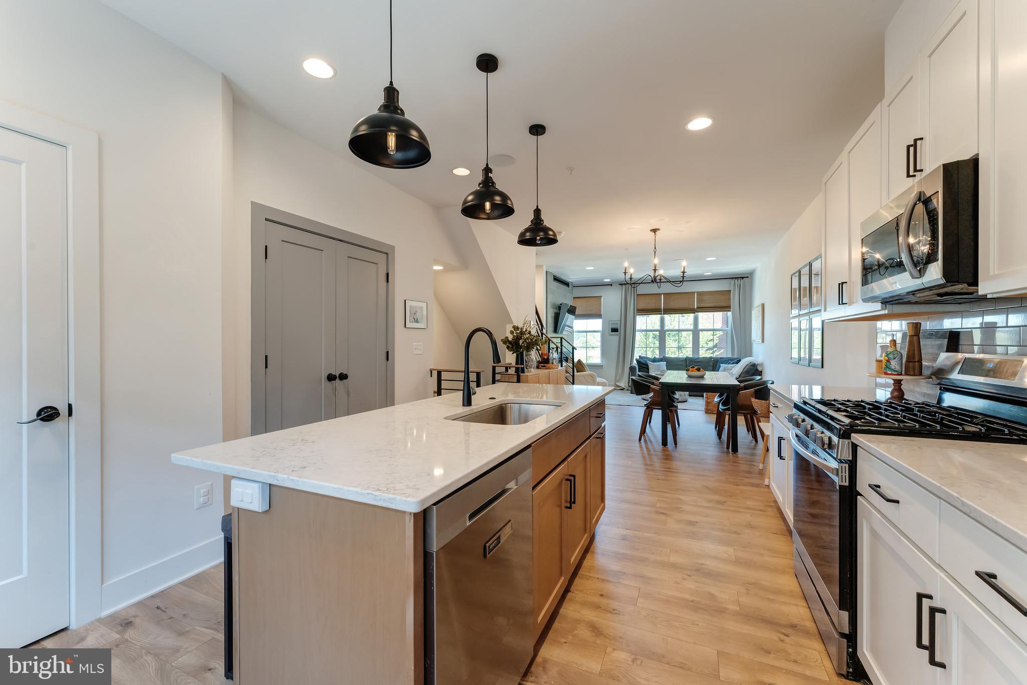 11237 Beaker Street Reston, VA 20190 - Photo 14 of 45 a very nice looking kitchen with a stove a sink a microwave oven a dining table and chairs with wooden floor