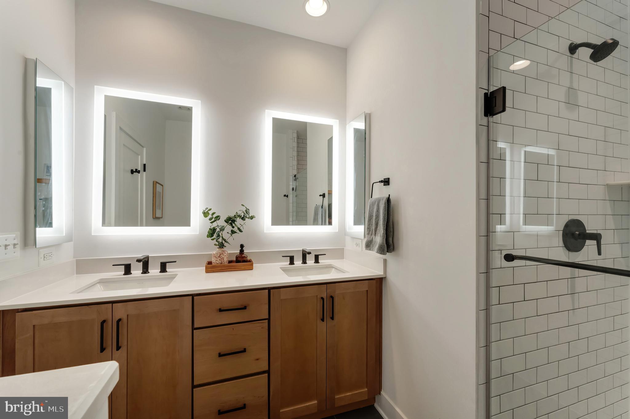 11237 Beaker Street Reston, VA 20190 - Photo 21 of 45 a bathroom with a sink a mirror and shower