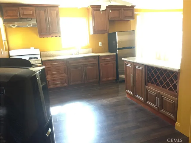 a kitchen with stainless steel appliances granite countertop a refrigerator and a sink