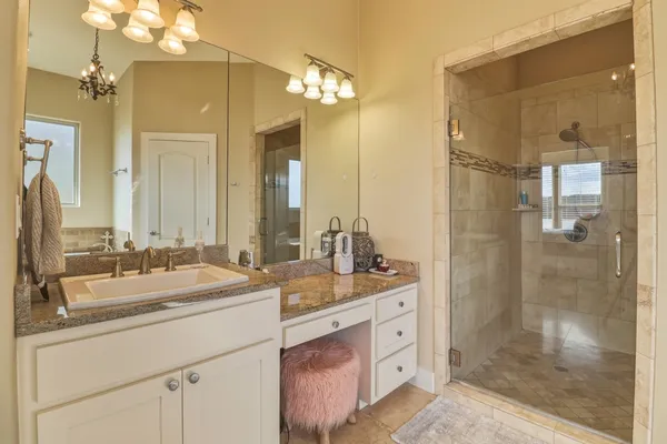 a bathroom with a double vanity sink mirror and shower