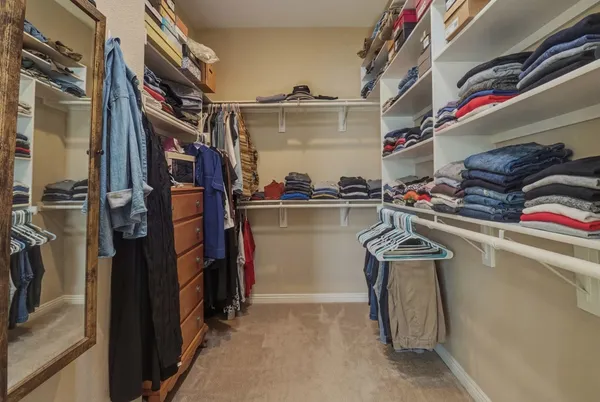 a view of walk in closet with clothes and shoes