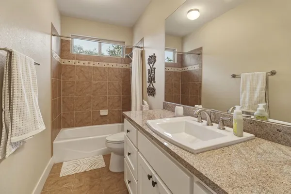 a bathroom with a granite countertop sink toilet and shower