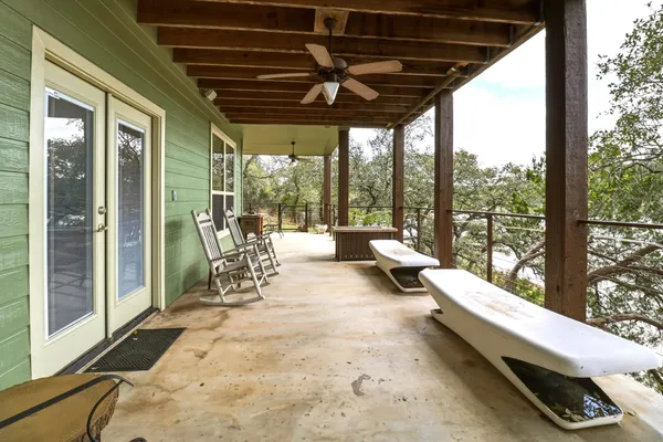 a view of a patio with lawn chairs floor to ceiling window and wooden floor