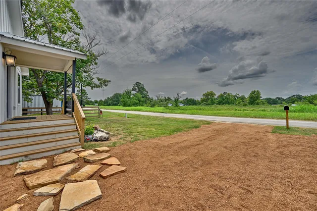 a view of a livingroom with a chandelier fan and windows