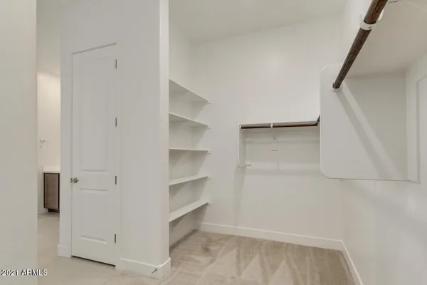 a view of walk in closet with empty racks