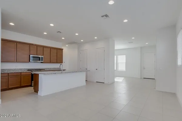 a large kitchen with stainless steel appliances a large counter top a stove and a sink