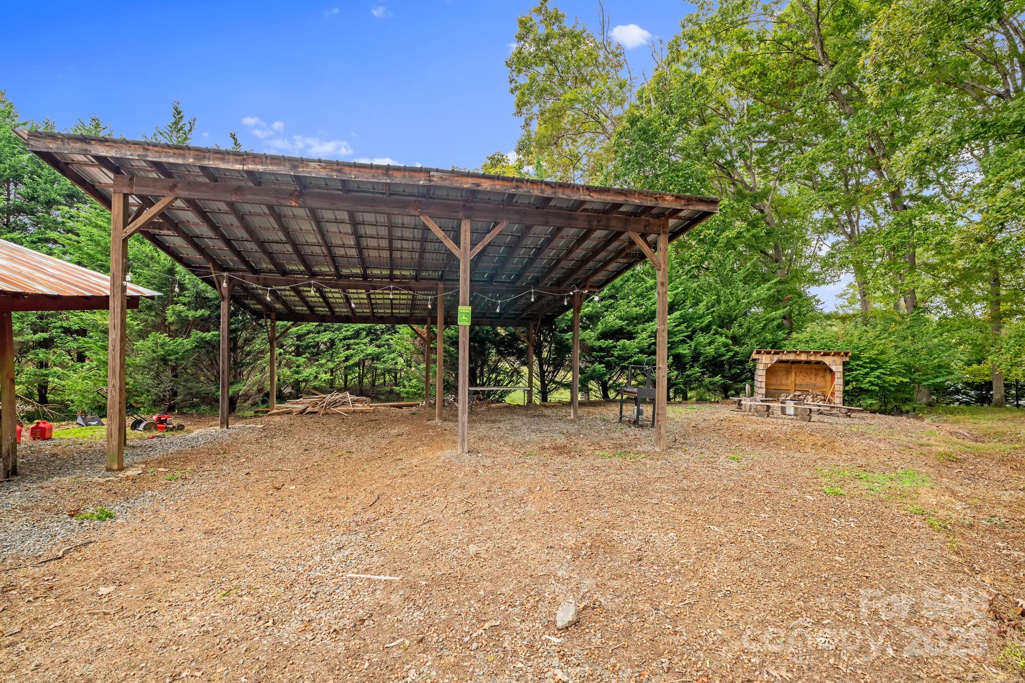 21 Presbyterian Church Road Mills River, NC 28759 - Photo 43 of 48 a backyard of a house with table and chairs under an umbrella