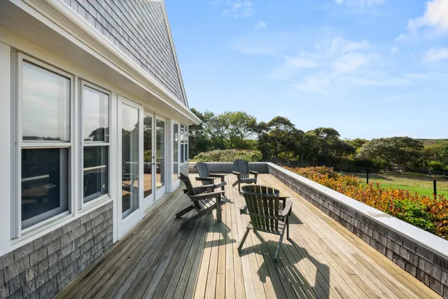 a front view of a house with garden and sitting area