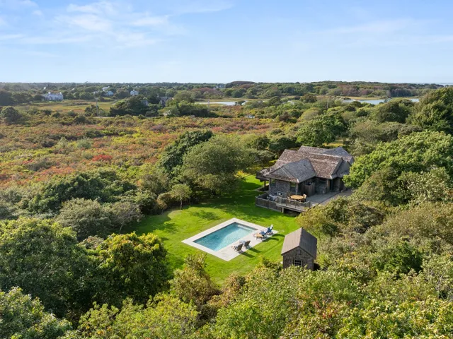 a front view of house with yard and trees in the background