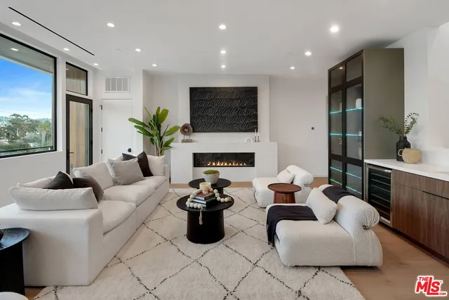 a living room with furniture fireplace and a large window