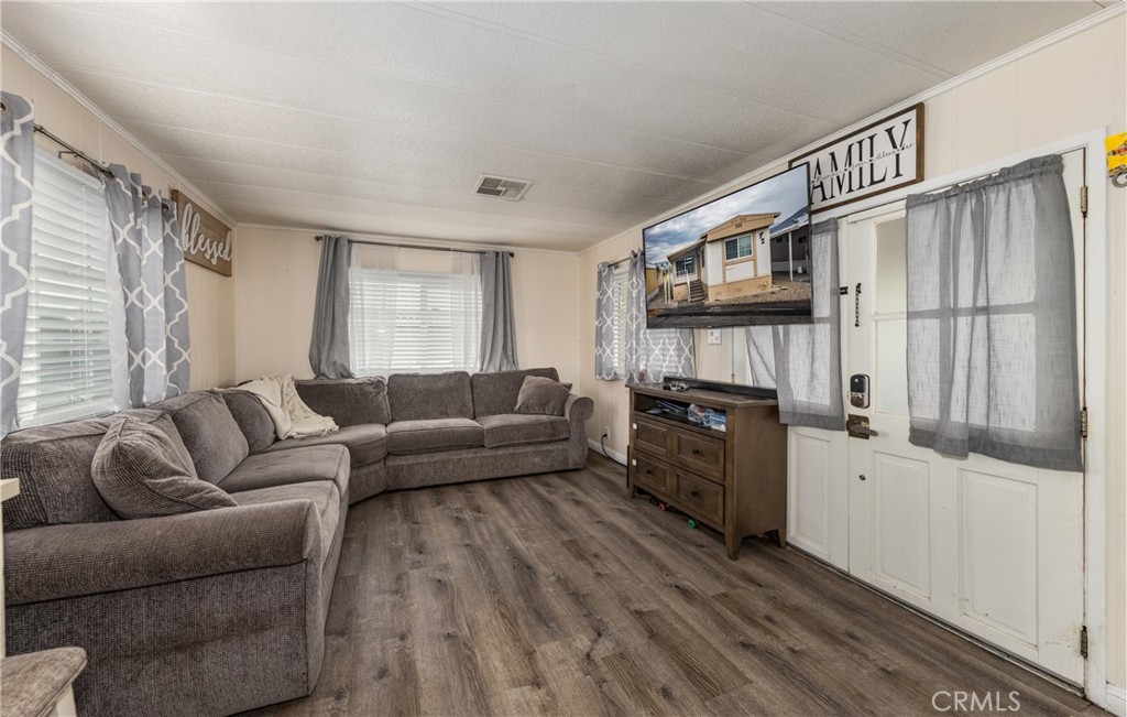 26838 9th Street, Unit F2 Highland, CA 92346 - Photo 3 of 18 a living room with furniture a fireplace and a flat screen tv