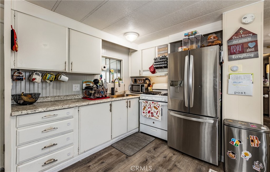 26838 9th Street, Unit F2 Highland, CA 92346 - Photo 6 of 18 a kitchen with stainless steel appliances a refrigerator sink and cabinets