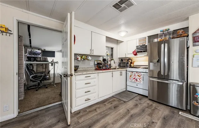 a kitchen with a refrigerator stove and white cabinets