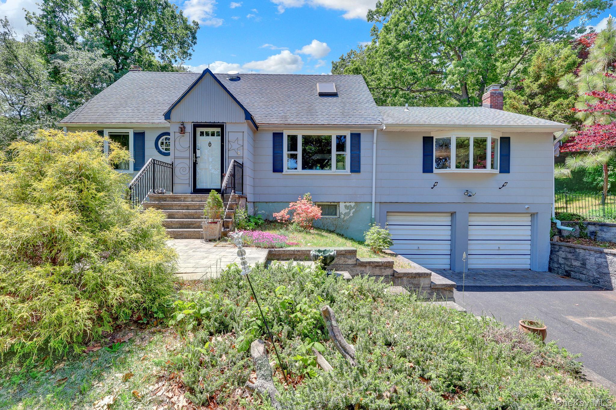 100 Elwood Road Northport, NY 11768 - Photo 1 of 39 Split-level residence featuring a light gray exterior with dark blue shutters and a prominent front entry with decorative side panels