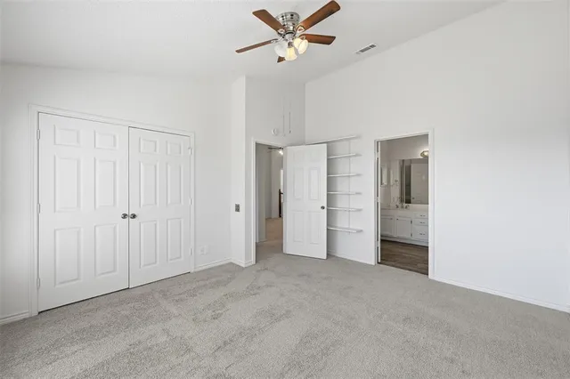 a view of an empty room with a ceiling fan