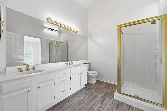 a spacious bathroom with a double vanity sink toilet and shower