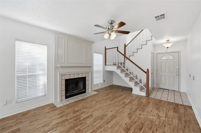 a view of a livingroom with wooden floor and a fireplace