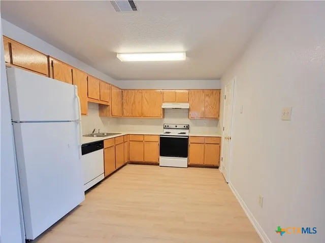 a kitchen with stainless steel appliances a refrigerator and a sink