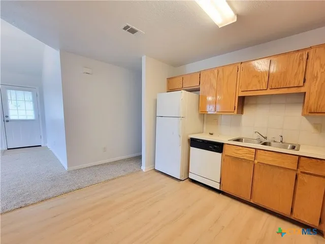a kitchen with stainless steel appliances granite countertop a refrigerator sink and cabinets