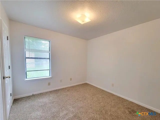 an empty room with a window and a mirror