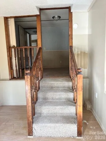 a view of staircase with white walls and railing