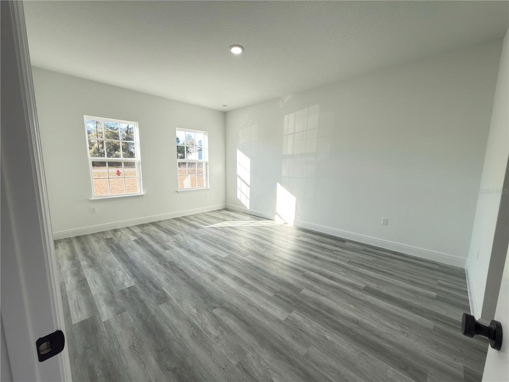 2703 Southwest 162nd Street Road Ocala, FL 34473 - Photo 12 of 39 an empty room with wooden floor and windows