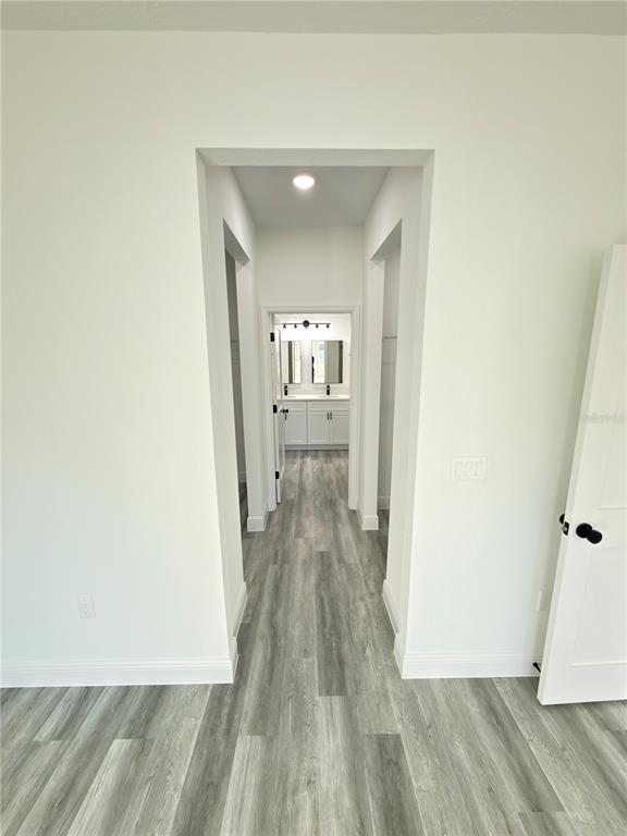 2703 Southwest 162nd Street Road Ocala, FL 34473 - Photo 13 of 39 a view of a hallway with wooden floor and a bathroom