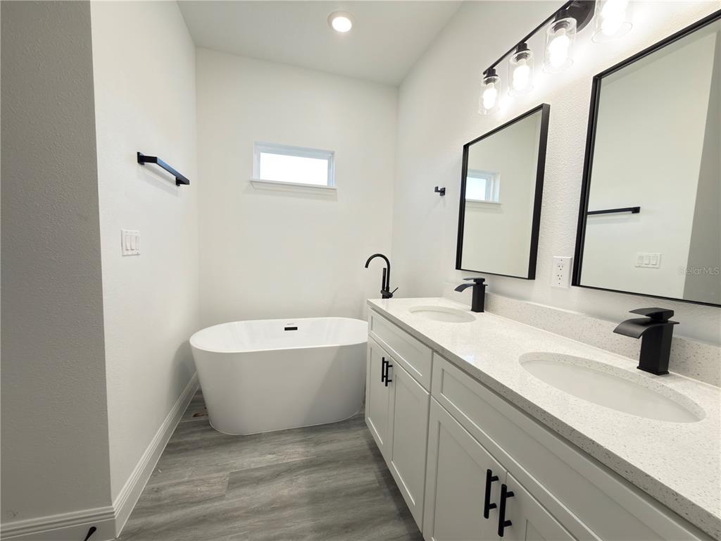 2703 Southwest 162nd Street Road Ocala, FL 34473 - Photo 15 of 39 a bathroom with a double vanity sink mirror and bathtub