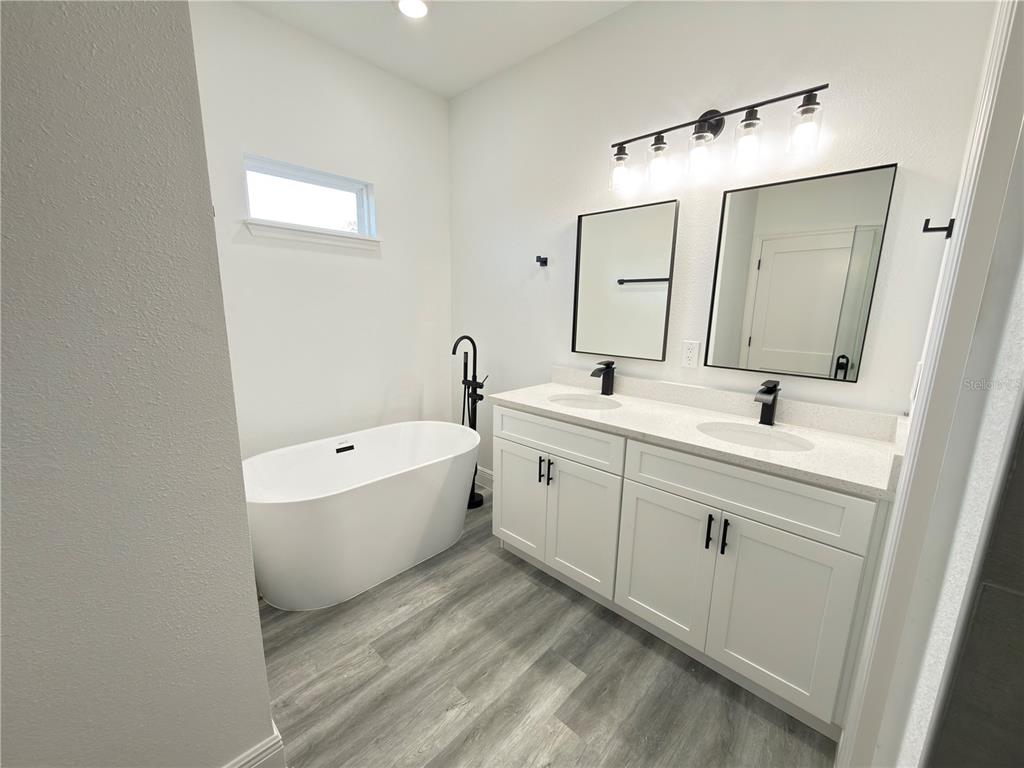2703 Southwest 162nd Street Road Ocala, FL 34473 - Photo 16 of 39 a spacious bathroom with a double vanity sink mirror and bathtub