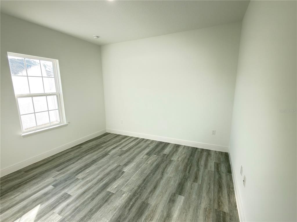 2703 Southwest 162nd Street Road Ocala, FL 34473 - Photo 30 of 39 an empty room with wooden floor and windows