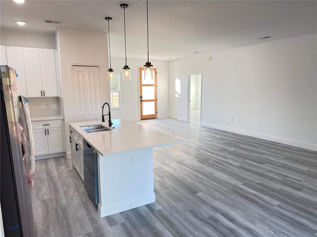 2703 Southwest 162nd Street Road Ocala, FL 34473 - Photo 8 of 39 a kitchen with stainless steel appliances granite countertop a sink a stove a refrigerator and island with wooden floor