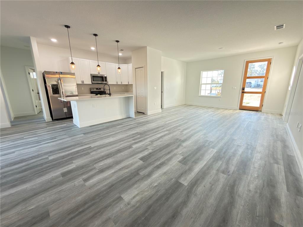 2703 Southwest 162nd Street Road Ocala, FL 34473 - Photo 10 of 39 a view of kitchen with kitchen island wooden floors and stainless steel appliances