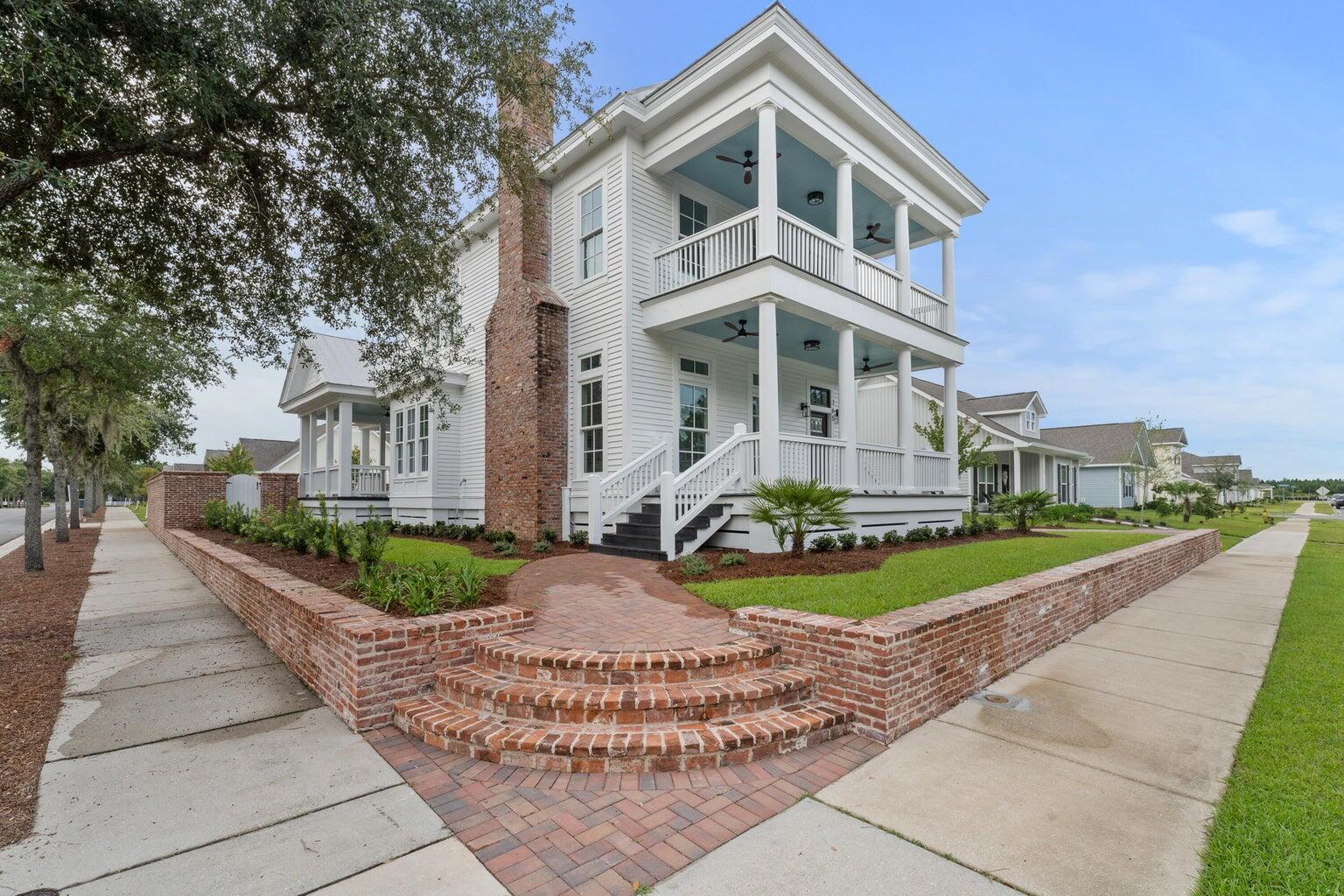 a front view of a house with a garden and trees