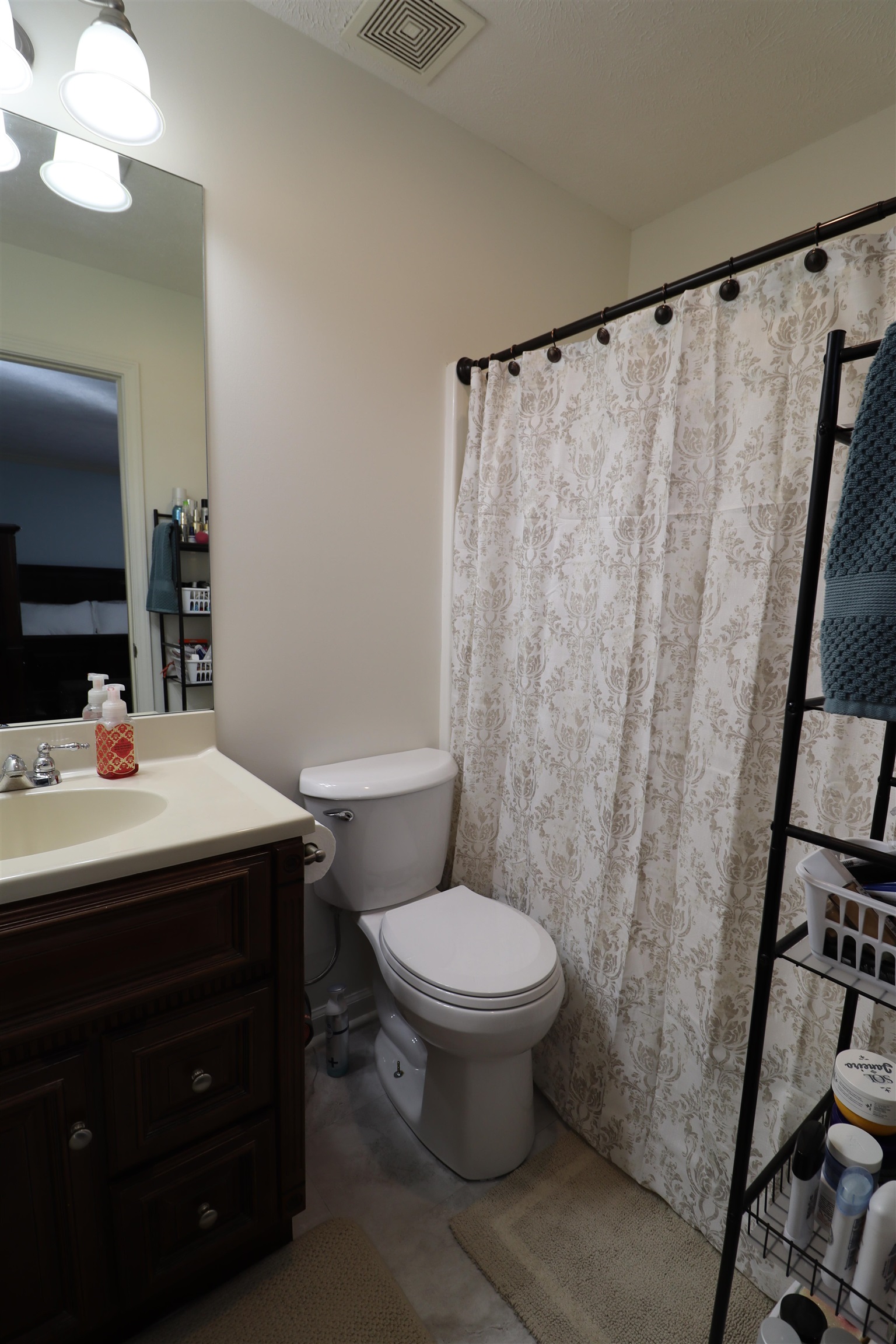 228 Edgewood Drive Adamsville, TN 38310 - Photo 23 of 37 Bathroom with toilet, vanity, visible vents, and a shower with curtain