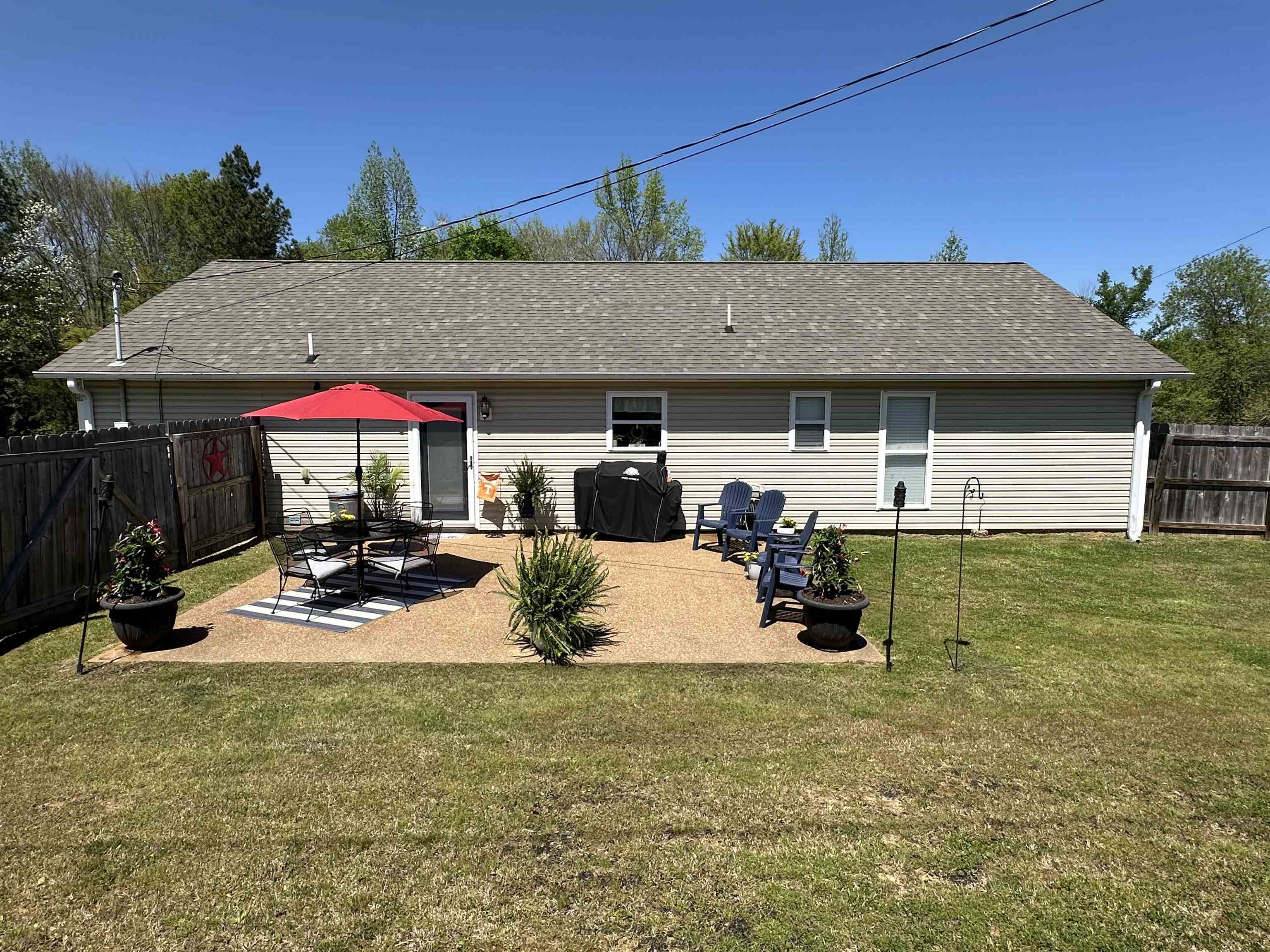 228 Edgewood Drive Adamsville, TN 38310 - Photo 4 of 37 Back of property featuring a patio area, roof with shingles, a yard, and a fenced backyard