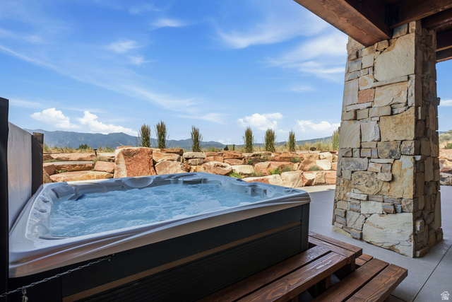 7885 North Rabbitbrush Court, Unit 13 Park City, UT 84098 - Photo 73 of 88 Outdoor spa with bubbling water, stone patio, and a natural rock retaining wall