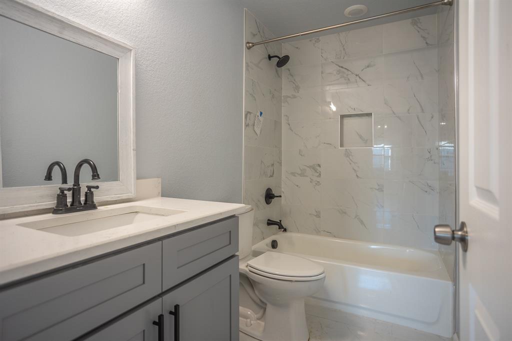 815 Ritchey Street Gainesville, TX 76240 - Photo 12 of 18 a bathroom with a sink toilet and shower