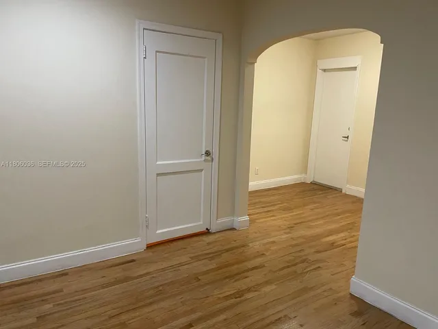 an empty room with wooden floor and closet