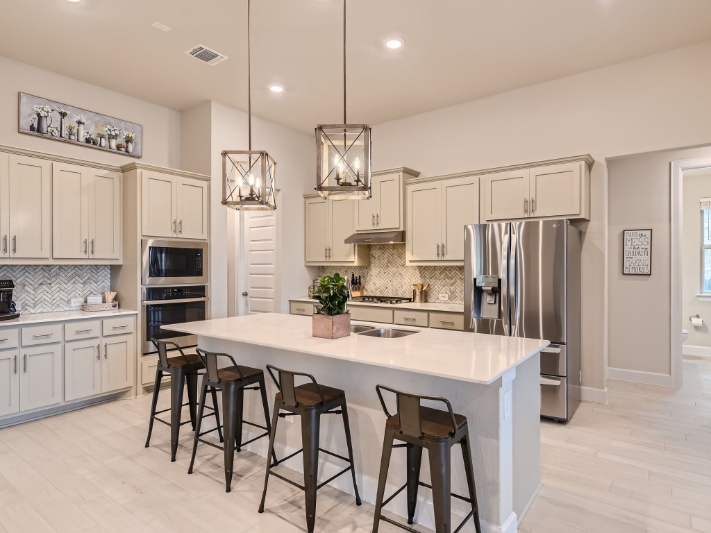a kitchen with kitchen island granite countertop a table chairs stainless steel appliances and cabinets