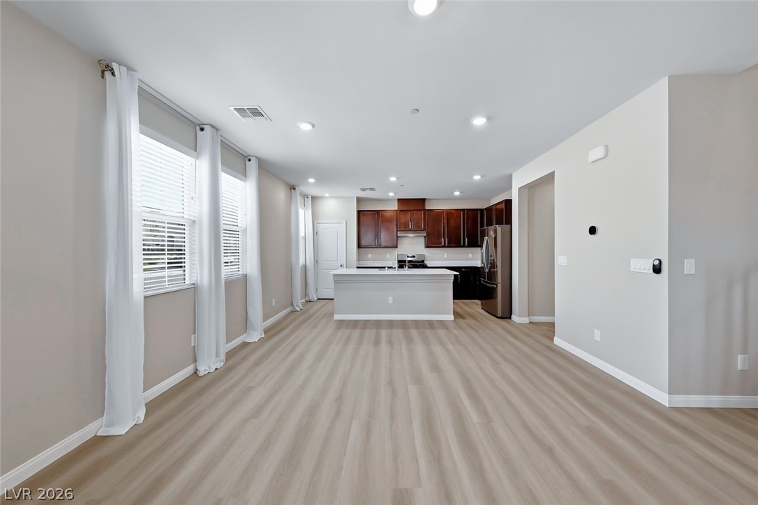 3564 Credere Lane Henderson, NV 89074 - Photo 40 of 40 Kitchen featuring open floor plan, a kitchen island with sink, light countertops, stainless steel appliances, and light wood-style flooring