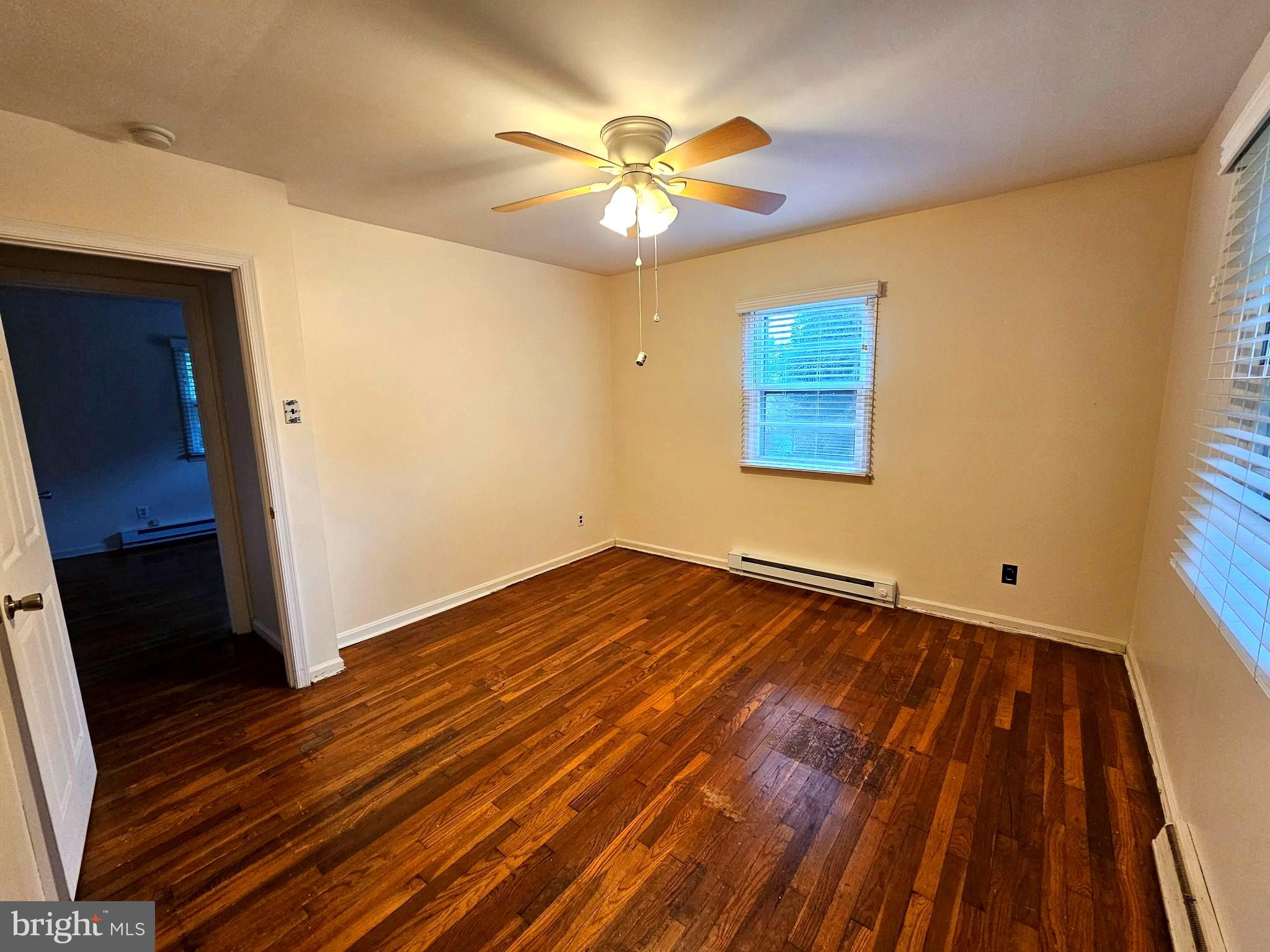 310 Bethel Road Paw Paw, WV 25434 - Photo 14 of 30 a view of an empty room with wooden floor and a ceiling fan